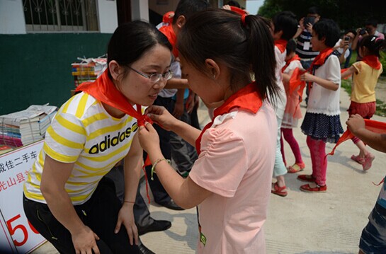 捐贈(zèng)儀式上，孩子們?yōu)閻?ài)心天使系上紅領(lǐng)巾