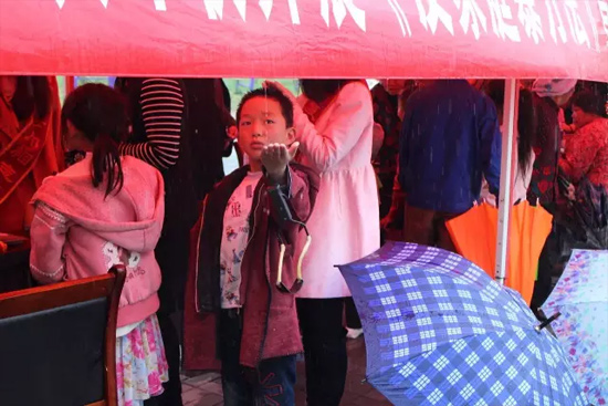 因為雨下的太大，小男孩玩起了接水游戲。