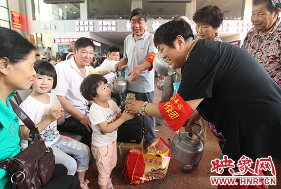 老年雷鋒團(tuán)”志愿者在候車(chē)廳為旅客送水。