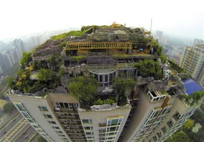 　　昨日，身穿橘黃色馬甲的工作人員在人濟(jì)山莊樓頂拆除違章建筑。新京報(bào)記者 吳江 攝