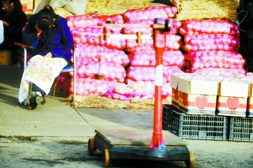 水果批發(fā)市場(chǎng)內(nèi)，沒(méi)有客戶時(shí)，商戶在繡十字繡