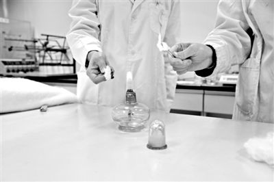 實驗人員操作的燃燒檢測法中，真蠶絲離開火焰就熄滅(左)。