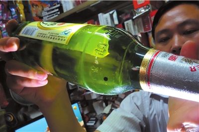 這瓶未開封的燕京啤酒內(nèi)有一顆黑色懸浮物。京華時報記者 徐曉帆 攝
