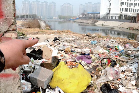 金水河長江路橋下河水發(fā)臭，水邊堆放眾多垃圾