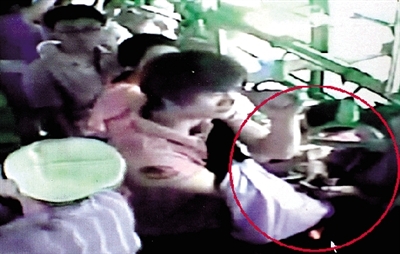 一名小偷拉開了乘客李女士的包，并在包里摸了足足3分多鐘。最終，李女士被偷了2.4萬多元錢。”(翻拍視