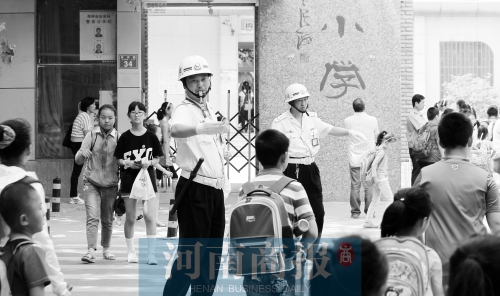 伊河路小學(xué)門口，兩名巡防隊(duì)員護(hù)送學(xué)生過馬路