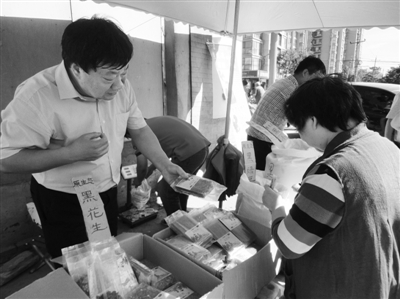 昨日，河南企業(yè)家劉春喜在京“練攤”，為顧客挑選綠豆。新京報(bào)記者 張玉學(xué) 攝