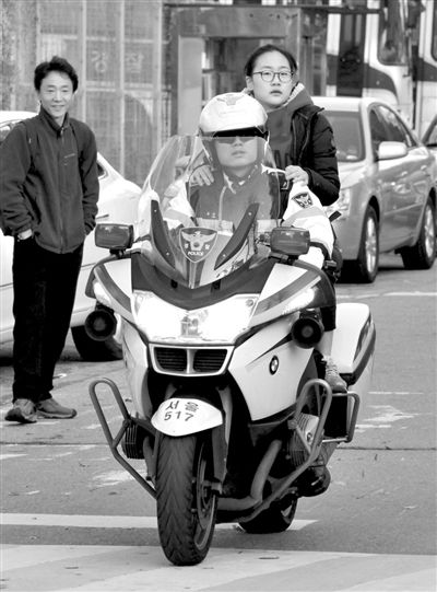 7日，首爾，警察將一名考生送抵考場(chǎng)。新華社發(fā)