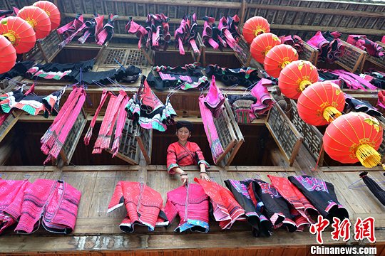 圖為紅瑤姑娘把紅衣晾曬出來(lái)。中新社發(fā) 韋吉陽(yáng) 攝