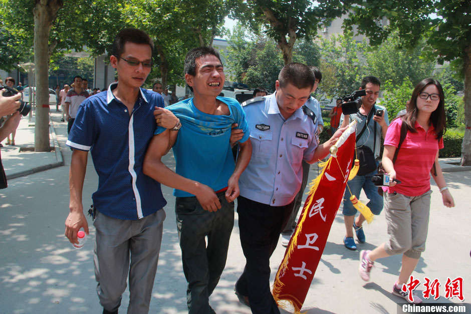 圖為獲救嬰兒父親情緒一度失控，當(dāng)?shù)鼐焦ぷ魅藛T對其進(jìn)行攙扶。張一辰 攝