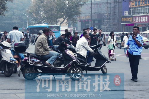 　火車站廣場北側(cè)，幾輛摩的正在等客