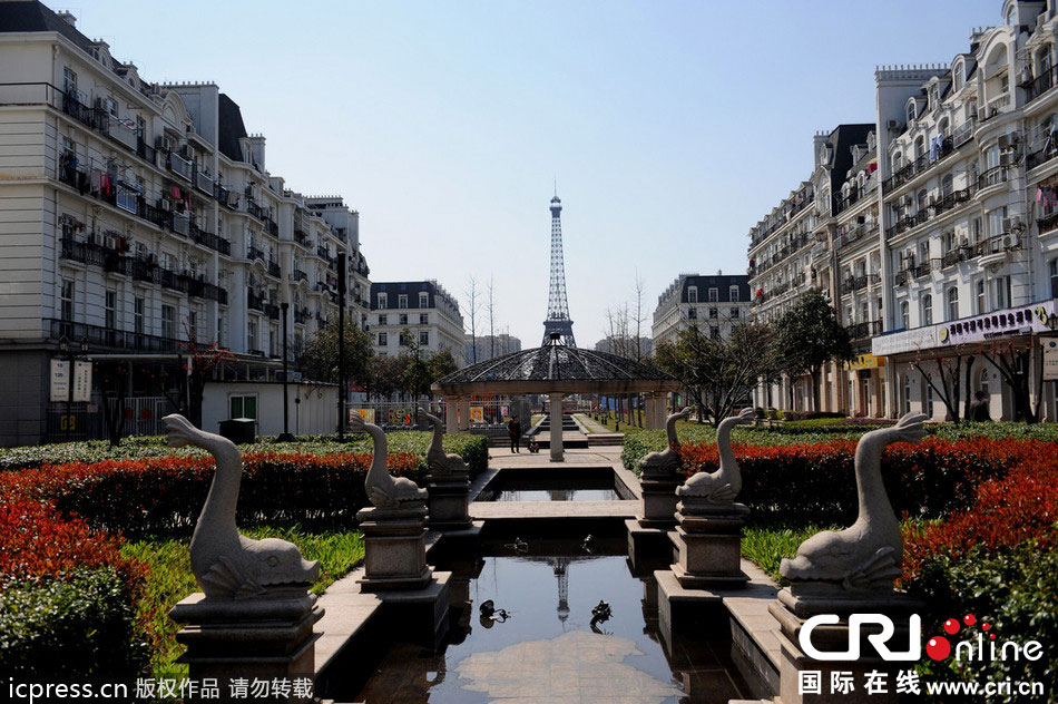 　2014年3月21日，杭州天都城，農(nóng)民在山寨埃菲爾鐵塔下耕作。圖片來源：東方IC