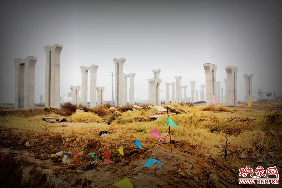 由于項目已經(jīng)停工數(shù)月，施工工地上很難見到工人，設(shè)備也很少，雜草叢生，顯得非?；臎?。