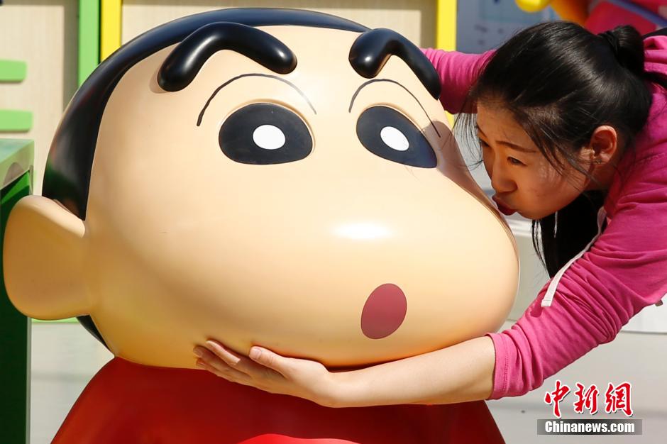 4月22日，游客與蠟筆小新合影?！跋灩P小新25周年紀(jì)念特展”日前在北京開展，吸引了不少市民游客。