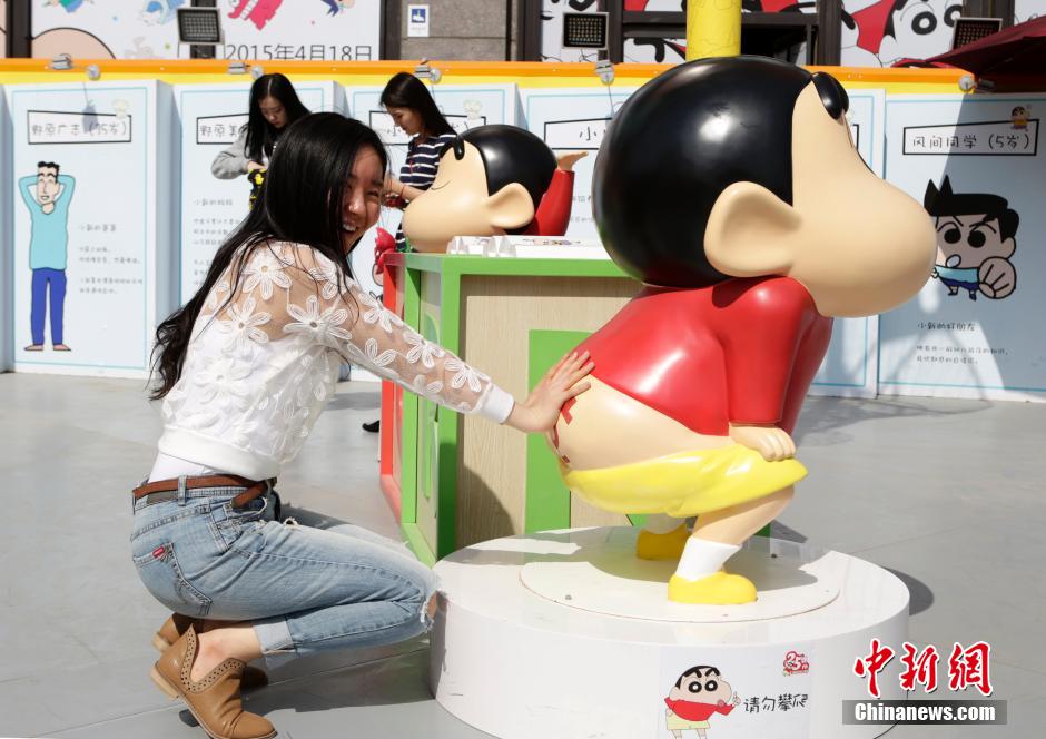 4月22日，游客與蠟筆小新合影?！跋灩P小新25周年紀(jì)念特展”日前在北京開展，吸引了不少市民游客。