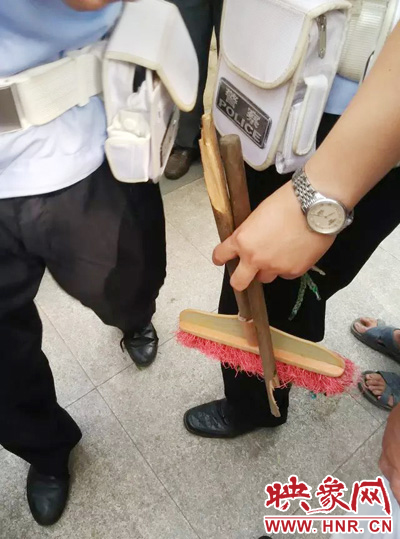 老太從環(huán)衛(wèi)工手中奪過(guò)掃帚，用腳踩斷，用力向環(huán)衛(wèi)工人的手上和腿上敲去。