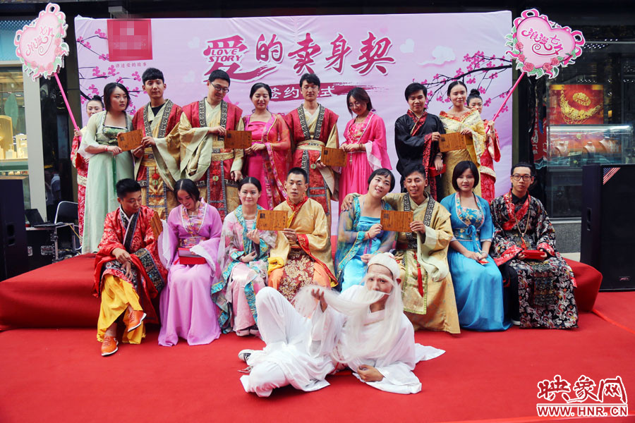 現(xiàn)場(chǎng)8對(duì)兒年輕男女舉起“賣身契”集體拍照。