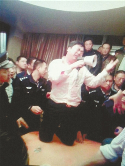 　4月19日，泰州市濱江工業(yè)園區(qū)管委會(huì)招待中心，一男子跪在酒桌上喊話求饒。李根 攝