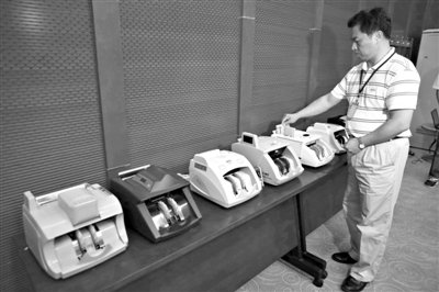 昨日，央行工作人員用各種驗(yàn)鈔機(jī)對(duì)C1F9假幣進(jìn)行測(cè)試，機(jī)器均能及時(shí)作出異常報(bào)警反應(yīng)。新京報(bào)記者 浦