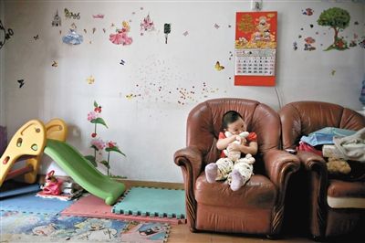 6月14日，未婚媽媽于軍的家里。女兒悅悅抱著兔子玩偶，在聽媽媽手機上的兒歌，這個4歲女孩喜歡兔子。