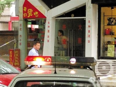 闖入面館的持刀男子與趕來的民警隔著玻璃門對峙，后店內(nèi)一名女童被其劫持。網(wǎng)友供圖
