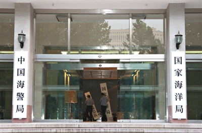 昨日，中國(guó)海警局掛牌成立。原國(guó)家海洋局和中國(guó)海監(jiān)總隊(duì)的牌匾被摘下，國(guó)家海洋局和中國(guó)海警局的新牌匾換上。黃冉 攝