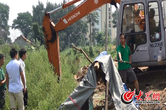 陳寶成手持自制刀斧守在挖掘機旁阻止便衣民警靠前。駕駛室內(nèi)，張朋珂正向受害人郭曉剛身上澆汽油。（視頻截圖）