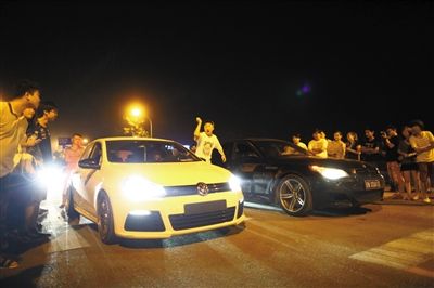 8月24日晚，東壩中街飆車現(xiàn)場(chǎng)，兩輛車并排等待出發(fā)指令，旁邊許多愛(ài)好者前來(lái)觀看比賽。新京報(bào)記者