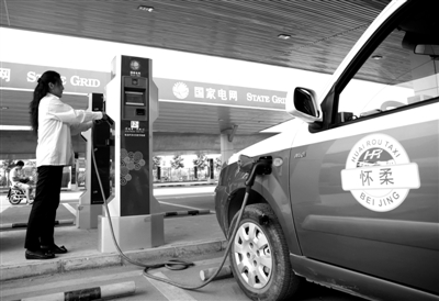 9月11日，懷柔區(qū)，電動(dòng)出租車司機(jī)正在為車輛充電。