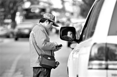 10月15日，朝陽區(qū)東大橋路，停車管理員從腰間掏出一個(gè)專用POS機(jī)，正在錄入停車信息。新京報(bào)記者 周崗峰 攝