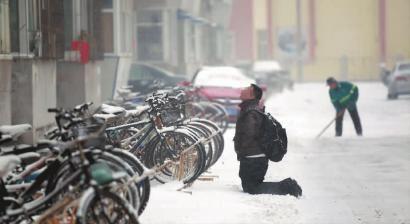 小伙子跪在樓前，一直抬頭看著樓上。 孫立國(guó)/攝