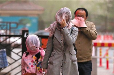 昨日下午，朝陽(yáng)區(qū)豆各莊，行人將紗巾裹在頭上防沙塵。