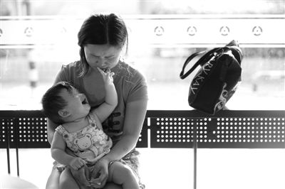 昨日，肯德基京廣中心店門(mén)口，姜女士提起跟養(yǎng)父母關(guān)系時(shí)落淚，懷中女兒笑著跟她玩。