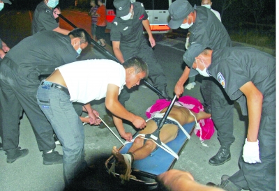 眾人合力將狂犬病發(fā)作的江某控制住。 孫東城 攝