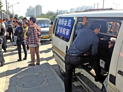 昨日，朝陽區(qū)看守所門前有人排隊。大門外還停有多輛寫有“律師會見”字樣的車。