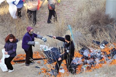 1月4日，連霍高速蘭州市榆中縣和平鎮(zhèn)段，一名警察舉著槍驅(qū)散哄搶橘子的村民。圖/CFP