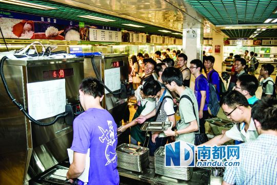 昨日，華南理工大學(xué)一食堂內(nèi)，學(xué)生們正在使用新安裝的自動(dòng)打飯機(jī)打飯。中新社發(fā)