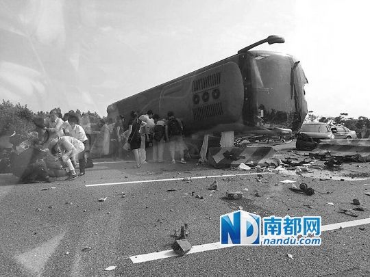 現場大客車側翻，玻璃碎落一地，車身卡在路邊水泥護欄上。 目擊者供圖