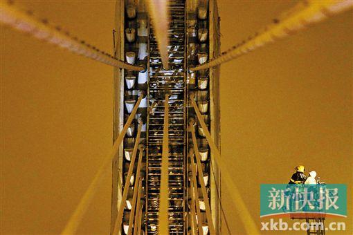 截至今日零時，男子仍未有下橋舉動。圖為公安和消防人員乘消防云梯在高空上和男子交談。