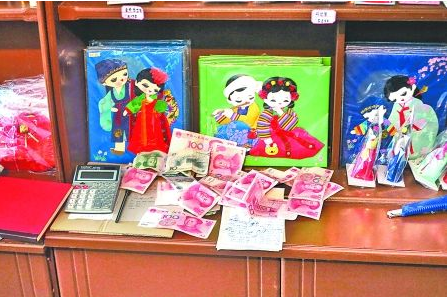 　　2012年6月21日，在朝鮮羅先特別市的一家商店里，柜臺上散落著一些人民幣。在朝鮮，人民幣比本國