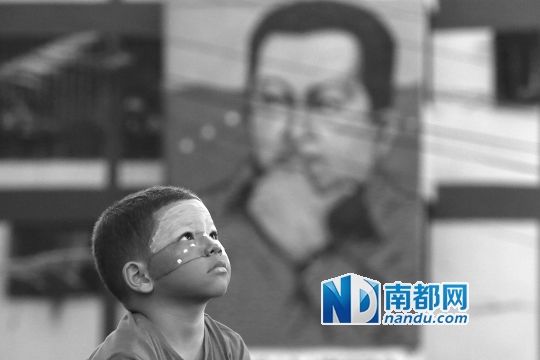 3月5日，一名委內(nèi)瑞拉兒童仰望天空，他身后是查韋斯的陵墓。