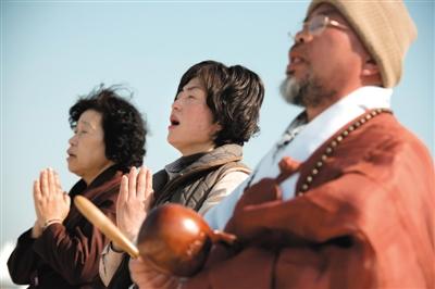 23日，一名僧侶引領(lǐng)人們?yōu)樗勒咂矶\。