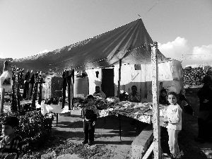 黎巴嫩一敘利亞難民營(yíng)，難民支起攤鋪賣衣服掙錢。