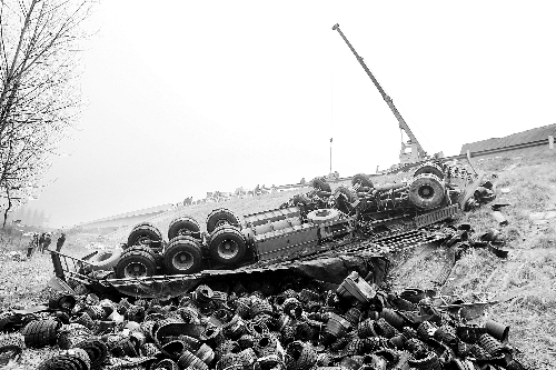 　一輛貨車沖開護欄翻下高速，輪胎散落一旁