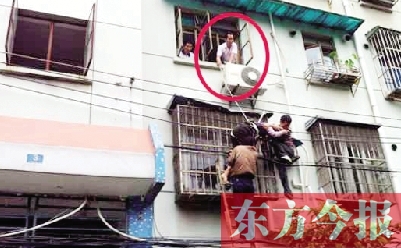 施救現(xiàn)場(chǎng)，劉鵬（圈內(nèi)）先用繩子捆住老太確保安全 勞動(dòng)報(bào)記者 郭娜 供圖