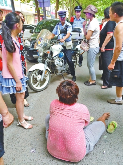 在鄭州優(yōu)勝南路東三街交叉口向東100米處，一名短發(fā)中年女子平躺在路南快車道上，身旁還有一只掉落的拖鞋