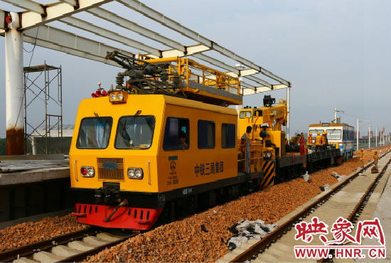 一列工程車從站臺(tái)駛過(guò)。