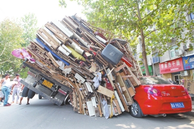 紅色小轎車被砸，卡在路邊動彈不得。