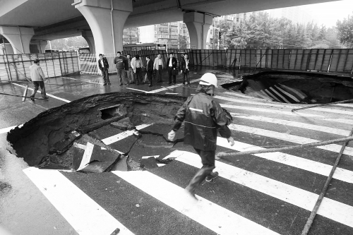 中原路西三環(huán)立交橋下由南向北原本4個車道，由于塌坑，而今3個車道被圍擋
