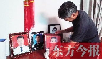 沉浸在悲痛之中的魯有海，擦拭著孩子的遺照